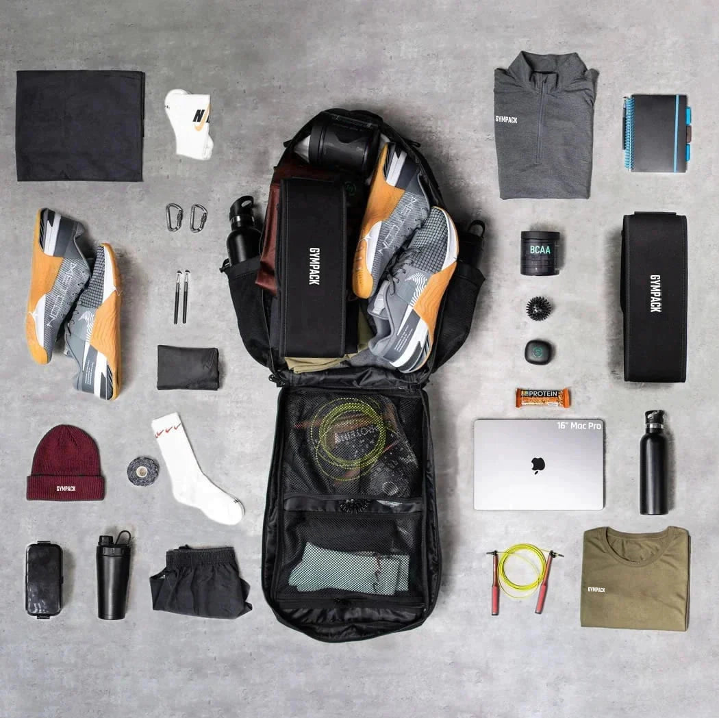 Mochila Gympack Pro 50L Preta Camuflada - Vista Completa com Itens de Treino e Uso Diário Organizados